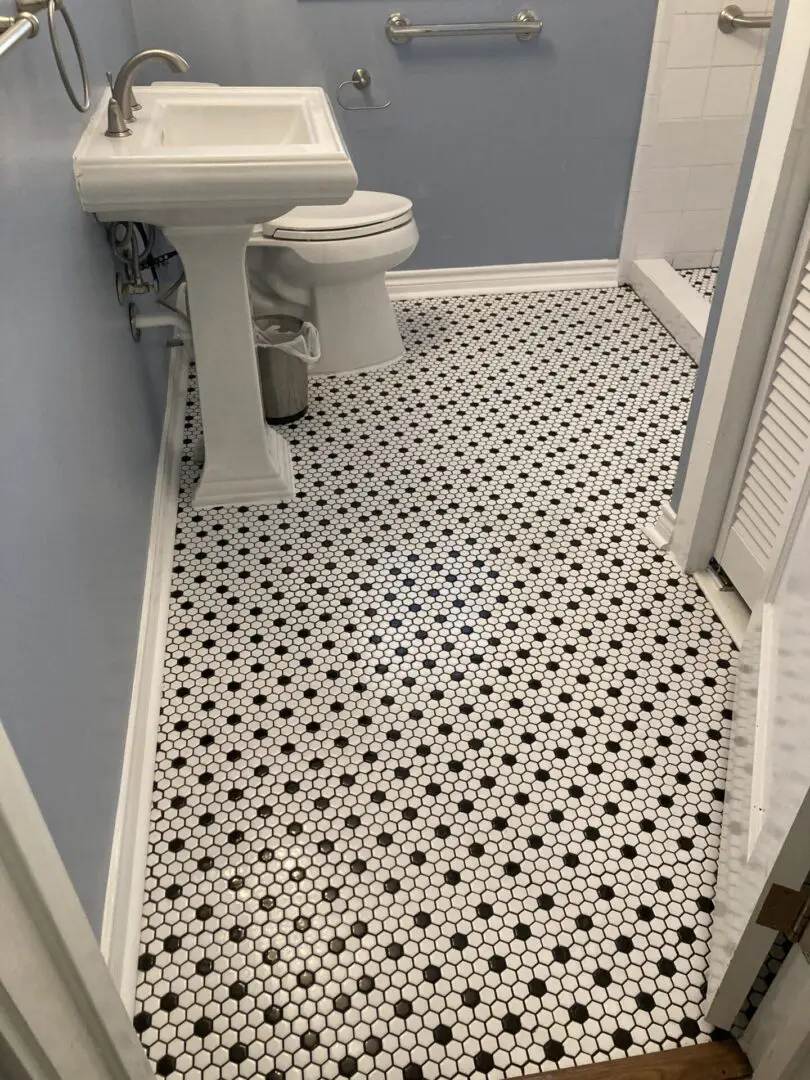 A bathroom with black and white tiles
