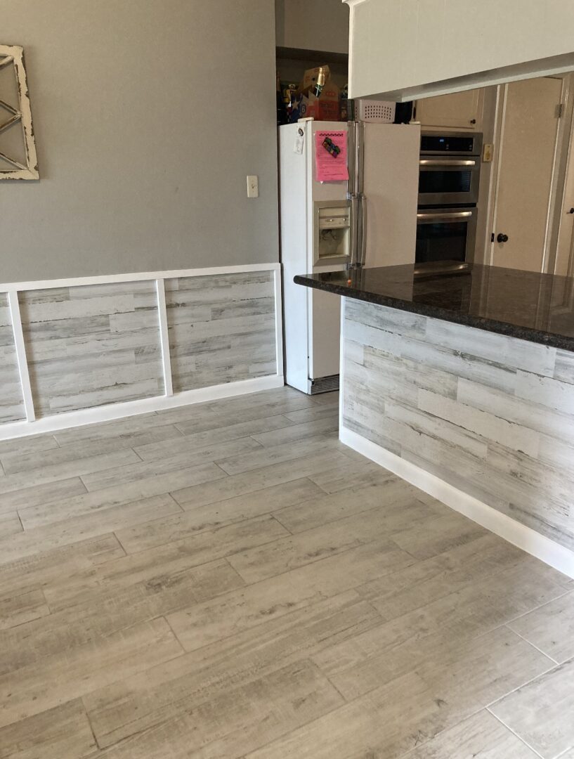 A kitchen area with light gray vinyl floor